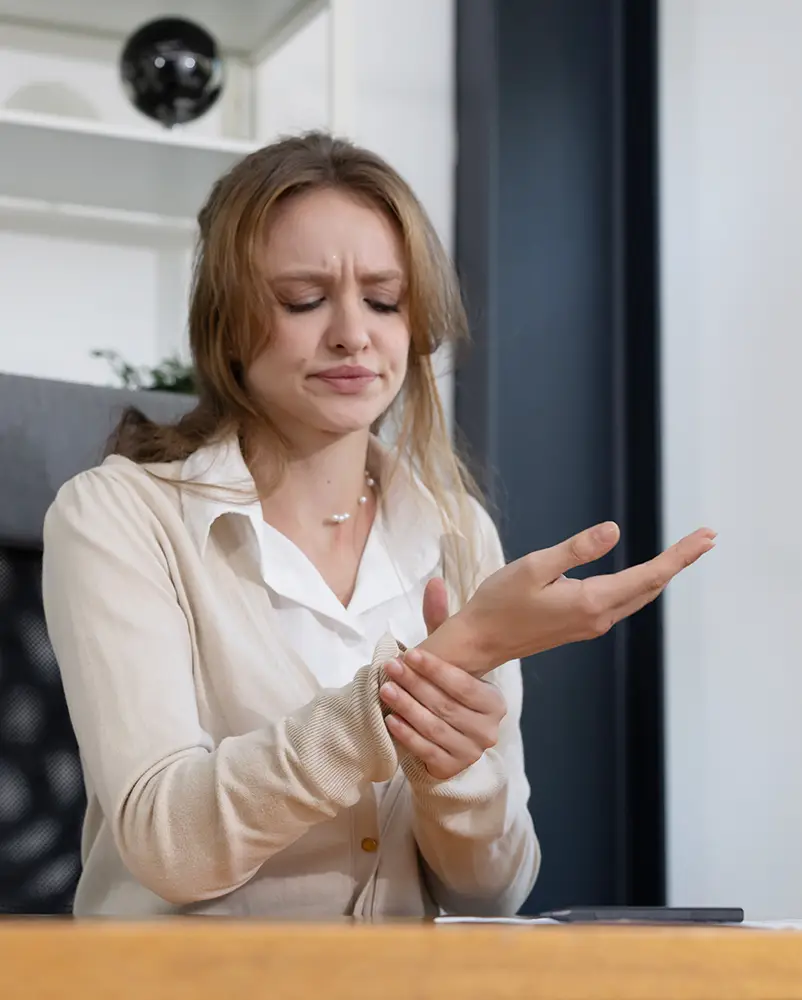 Mujer con signos de dolor en muñeca