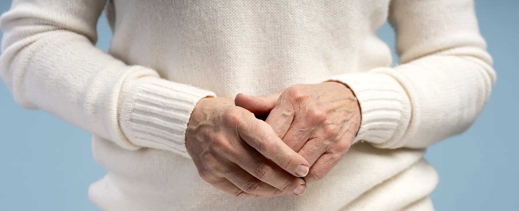 Mujer apretando las manos por dolor en los dedos